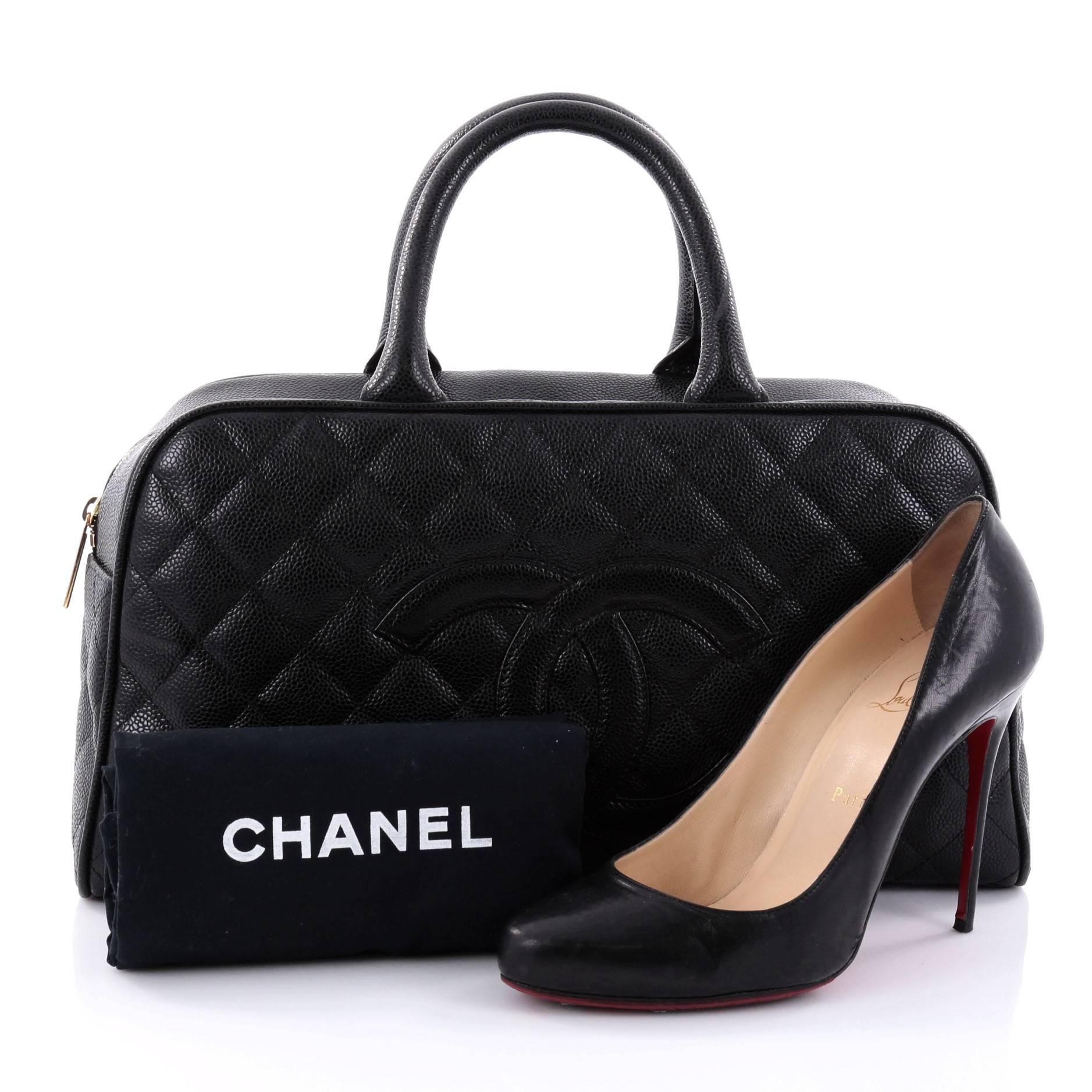 This authentic Chanel Timeless CC Bowler Bag Quilted Caviar Large creates a fun and modern twist to the classic Chanel design. Crafted in black quilted caviar leather, this bowler bag features dual-rolled leather handles, CC logo beautifully