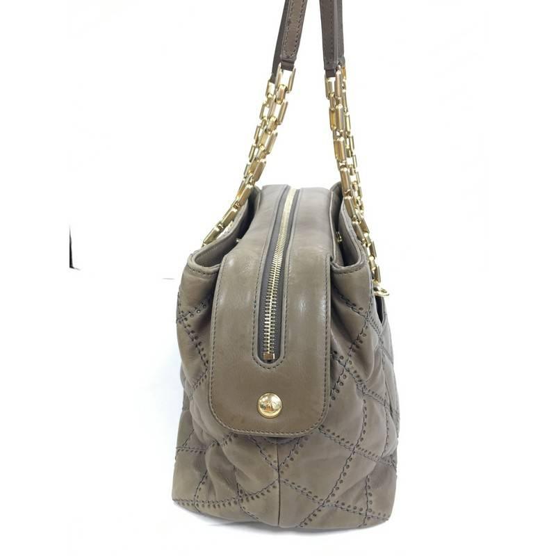 This authentic Chanel Retro Chain Zip Satchel Quilted Calfskin Small is a classic design made for everyday use. Crafted from taupe calfskin leather, this bag features classic Chanel quilted diamond design, chain-link strap with leather shoulder pad,