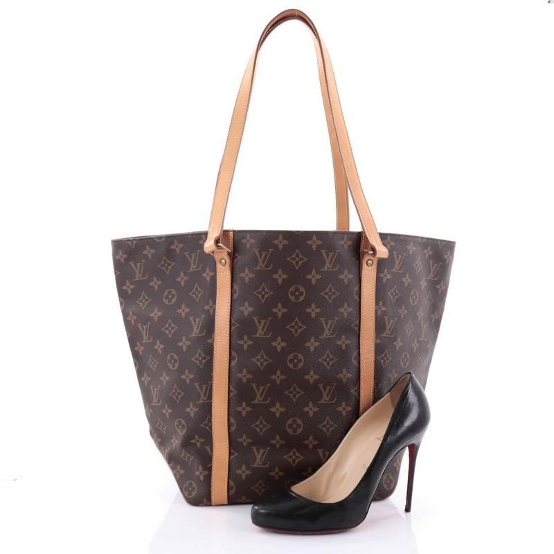 This authentic Louis Vuitton Shopping Sac Handbag Monogram Canvas MM is understated in its functionality and wearability. Crafted with Louis Vuitton's monogram coated canvas, this bag features tall dual vachetta leather straps, extended sides for