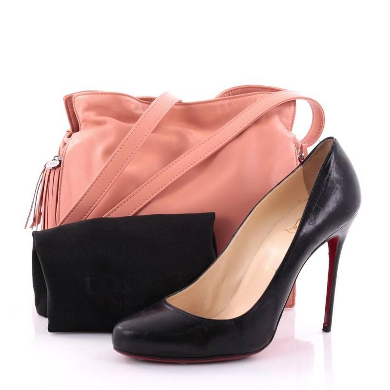This authentic Loewe Flamenco Bag Leather is simply a must-have for your wardrobe. Crafted in pink leather, this classy stylish bag features leather shoulder strap, drawstring top with oversized tassels, and gunmetal-tone hardware accents. Its