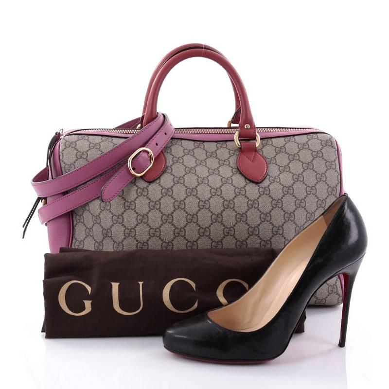 This authentic Gucci Convertible Boston Bag GG Coated Canvas Medium updates its classic Boston style with a fresh and youthful twist. Crafted in brown GG coated canvas and pink leather trims, this stylish Boston bag features dual-rolled red leather