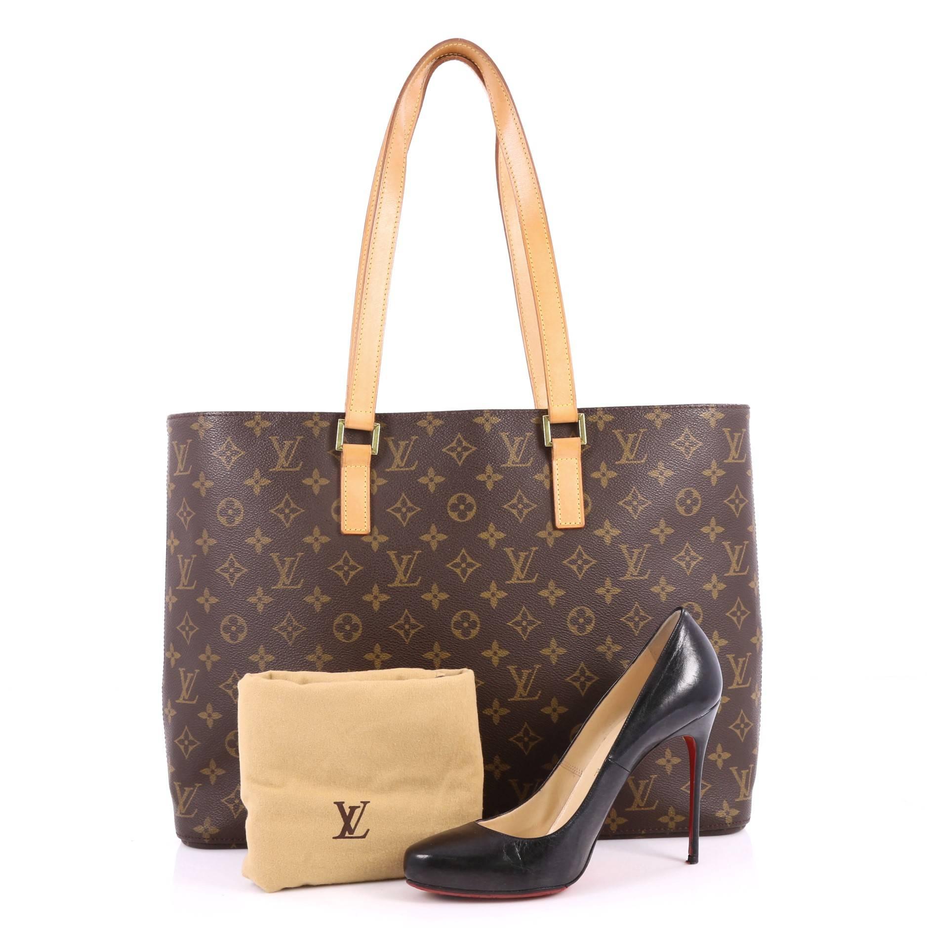 This authentic Louis Vuitton Luco Handbag Monogram Canvas is a classic tote that displays fashion and functionality all rolled into one. Crafted with the brand's iconic brown monogram coated canvas, this tote features dual flat leather handles, a