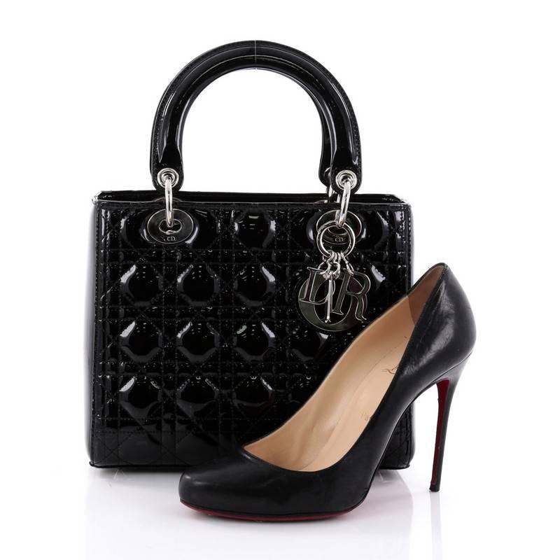 This authentic Christian Dior Lady Dior Handbag Cannage Quilt Patent Medium is an elegant classic bag that every fashionista needs in her wardrobe. Crafted from black patent leather in Dior's iconic cannage quilting, this boxy bag features short