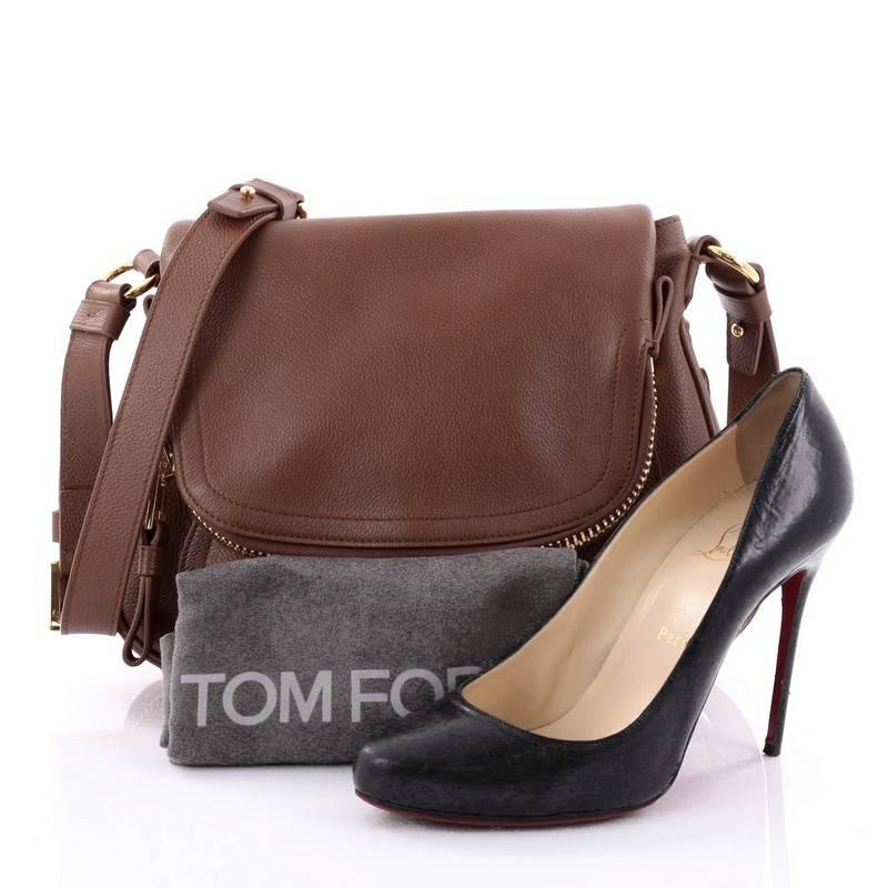 This authentic Tom Ford Jennifer Crossbody Bag Leather Medium redefines modern luxury with timeless elegance. Crafted in brown leather, this signature saddle shoulder bag features an adjustable crossbody strap, zip-top fold-over flap, expandable