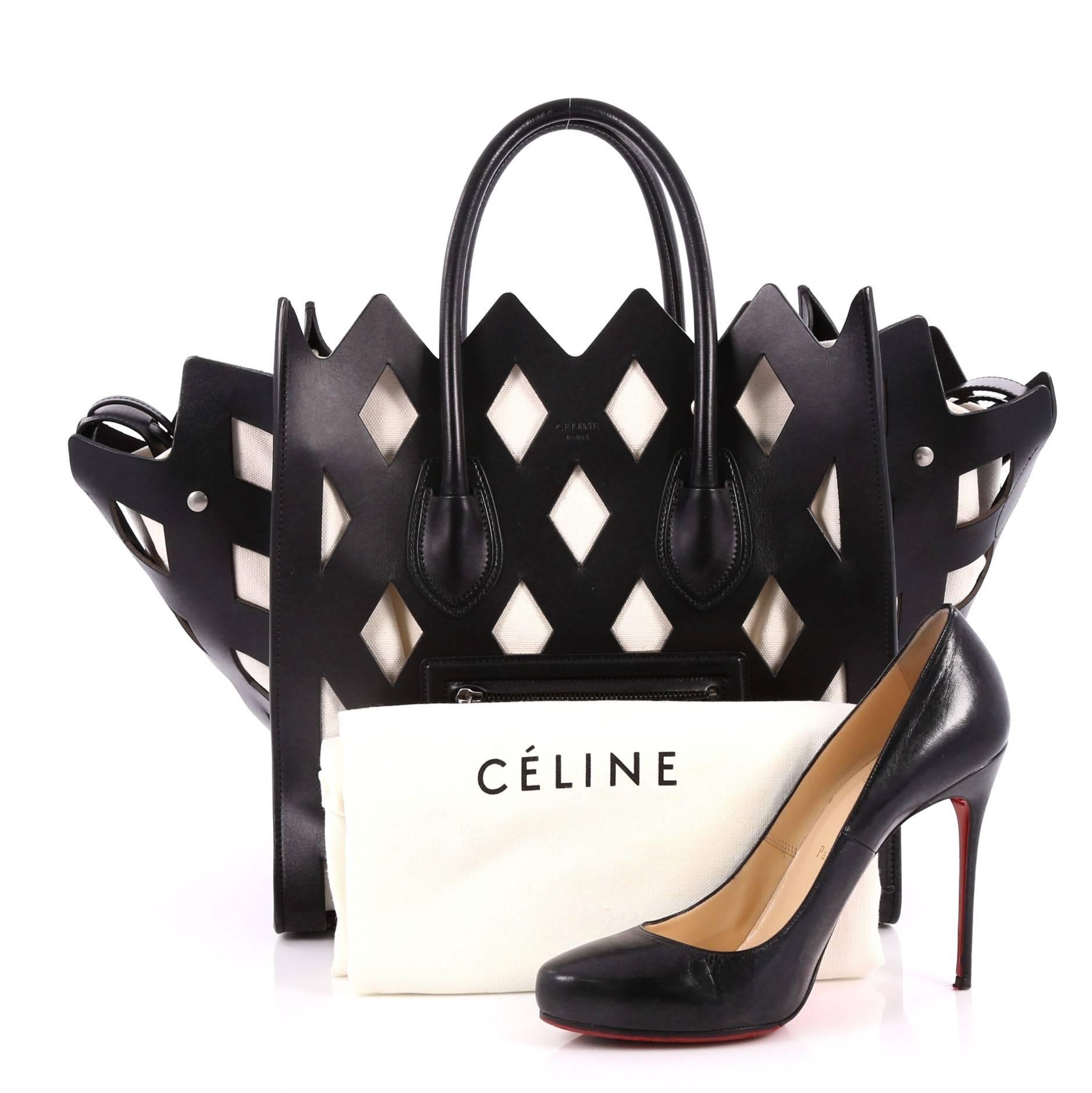 This authentic Celine Phantom Handbag Cut Out Leather Medium is a fresh take on the iconic Phantom bag. Crafted in black cut-out leather, this stand-out bag features dual rolled leather handles, embossed logo at front, exterior zip pocket,