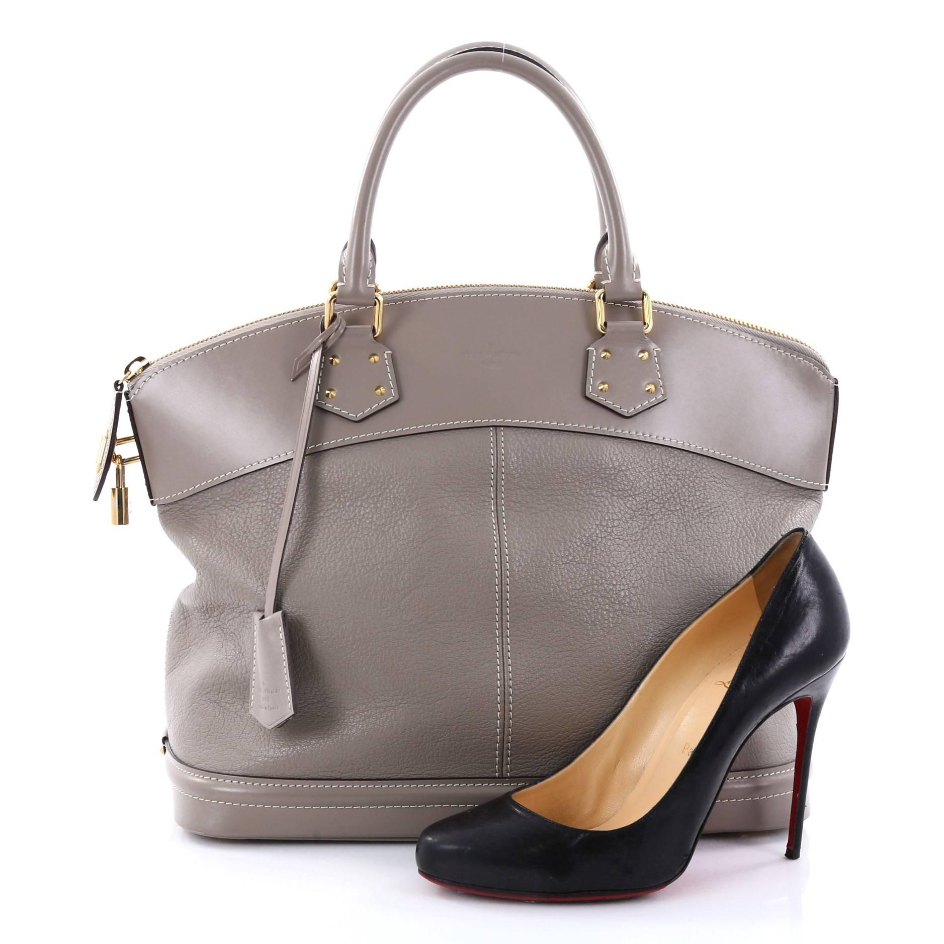 This authentic Louis Vuitton Suhali Lockit Handbag Leather MM is updated to the present borrowing from its 1958 original design with a modern twist. Crafted from grey suhali leather, this functional tote feature dual-rolled handles, sturdy base,