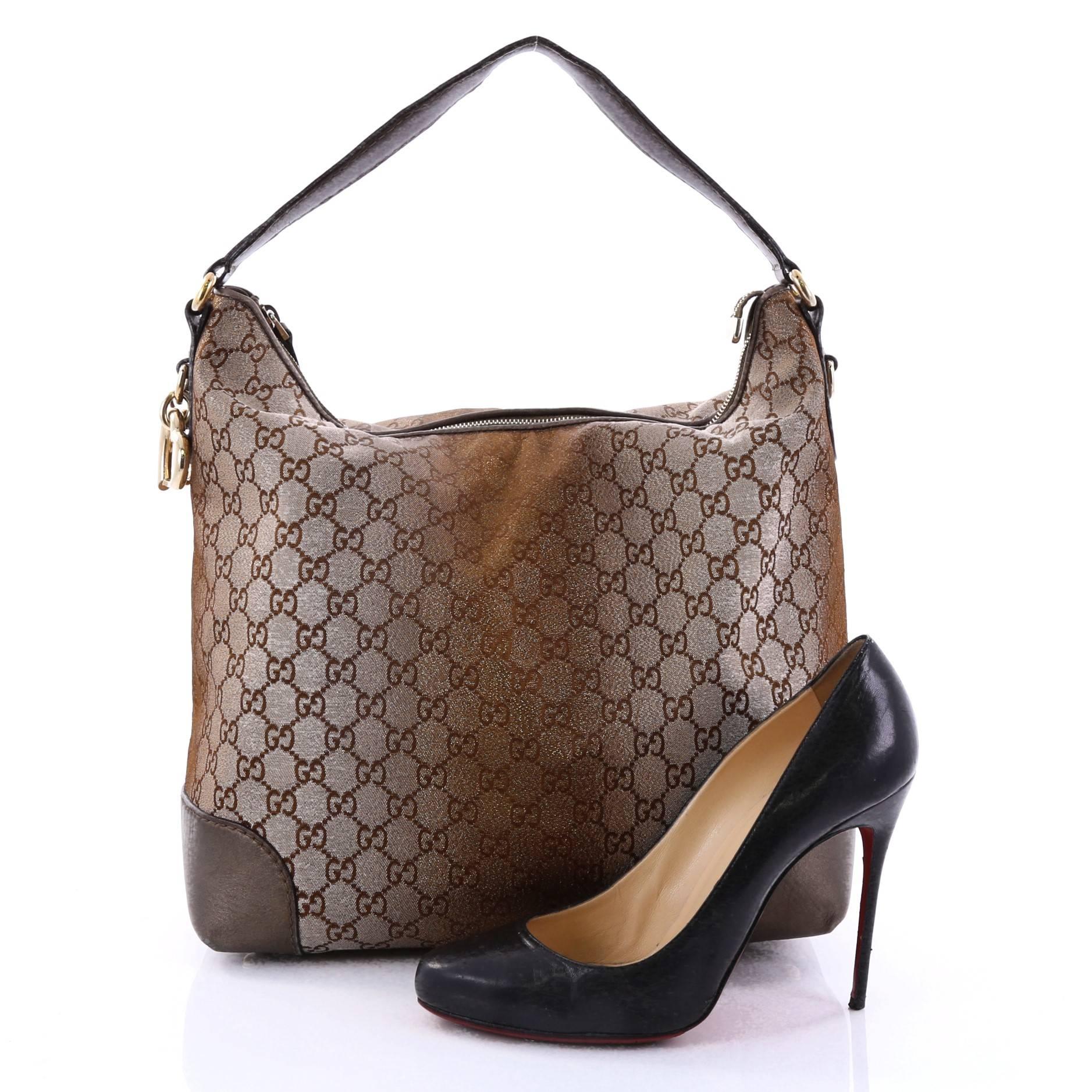 This authentic Gucci Heart Bit Hobo Monogram Lurex Medium is a sophisticated and chic style tote ideal for everyday wear. Crafted from brown monogram lurex, this bag features looping leather shoulder strap, brown leather trims, heart-shaped charm,