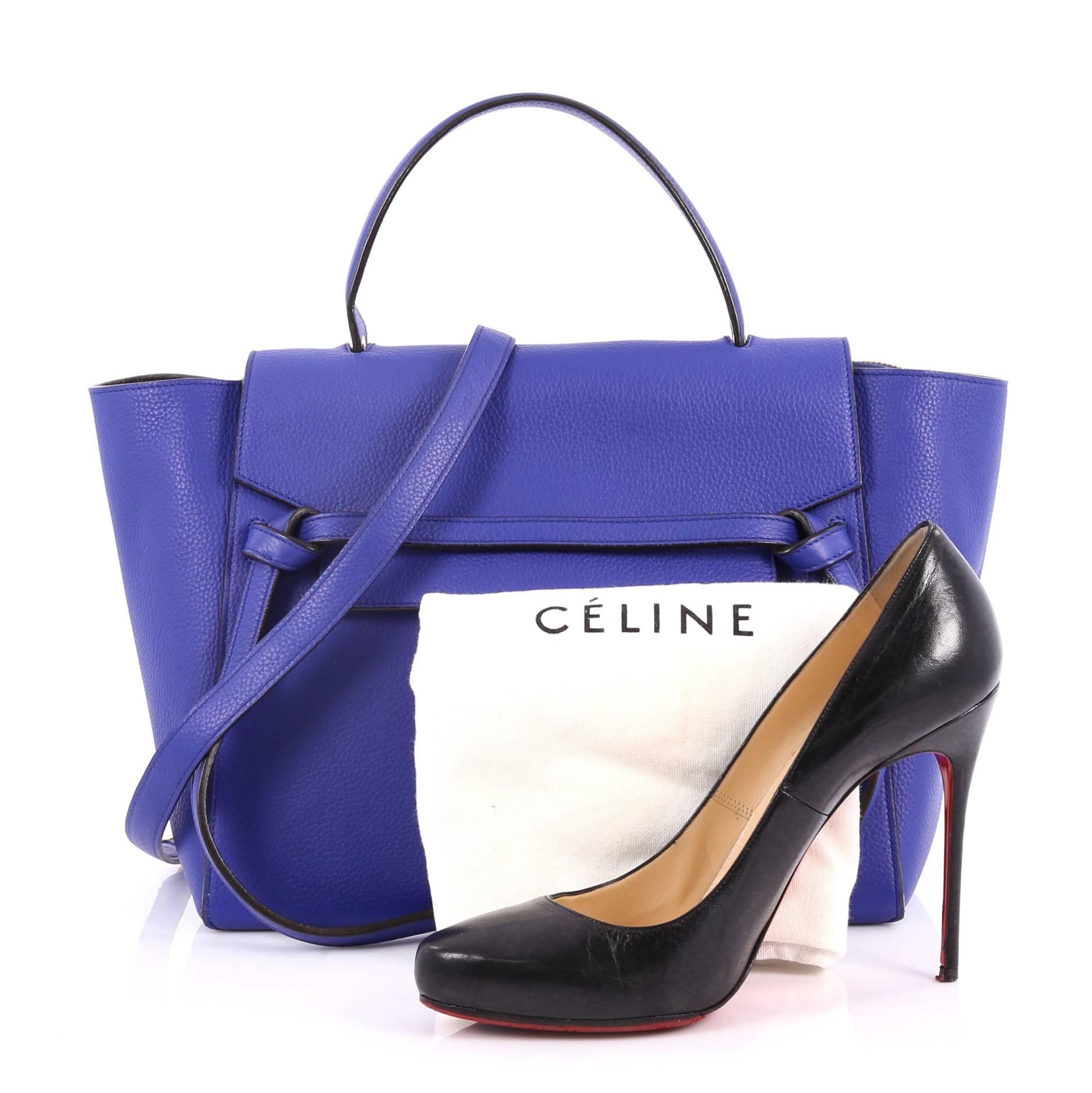 This authentic Celine Belt Bag Grainy Leather Mini is sure to make a statement. Crafted from blue grainy leather, this bold and beautiful bag features expanded wings, looped single top handle, top flap slide closure, knotted ties, zipper pocket at