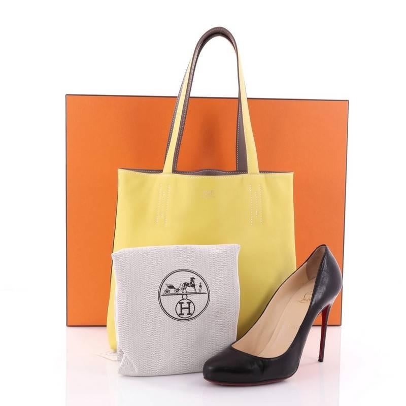 This authentic Hermes Double Sens Tote Veau Sikkim 36 combines a simple and functional style from Hermes perfect for everyday use. Crafted from soft Lime and Gris Souris veau sikkim leather, this reversible tote features all-around white contrast