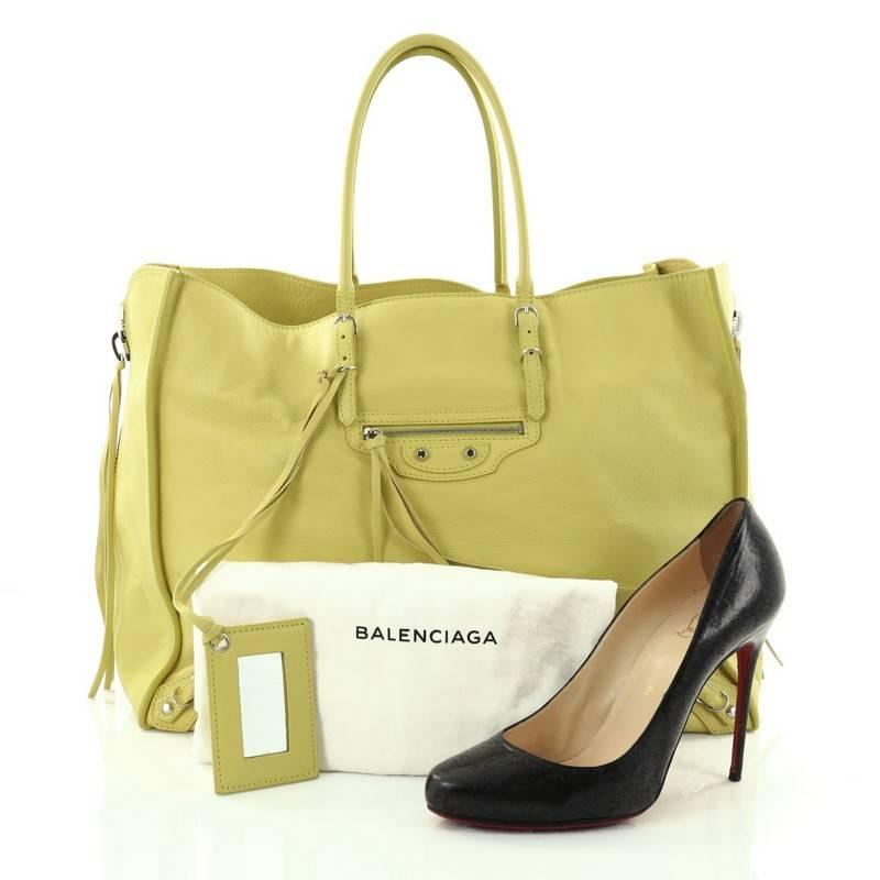This authentic Balenciaga Papier A4 Zip Around Classic Studs Handbag Leather Large is a modern-minimalist accessory made for any fashionista. Crafted in yellow leather, this handbag features dual-rolled slim handles, zip sides that allow the bag to