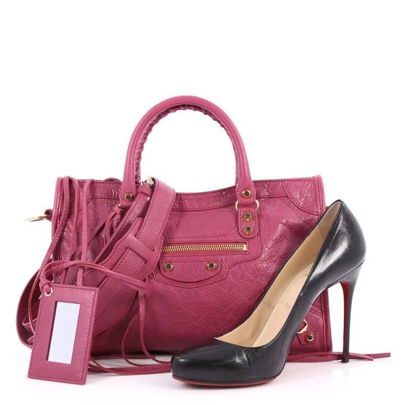 This authentic Balenciaga City Classic Studs Handbag Leather Small is for any on-the-go fashionista. Constructed in magenta leather, this popular bag features dual braided woven handle straps, front zip pocket, iconic Balenciaga classic studs and