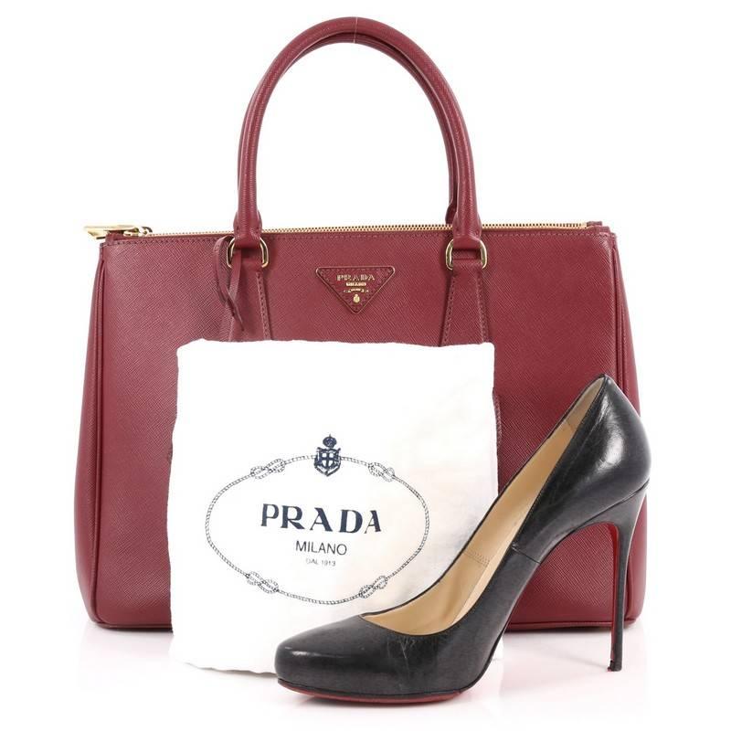 This authentic Prada Front Pocket Double Zip Lux Tote Saffiano Leather Medium is a stylish luxury. Crafted from burgundy saffiano leather, this boxy tote features side snap buttons, raised Prada logo, dual-rolled leather handles, exterior front