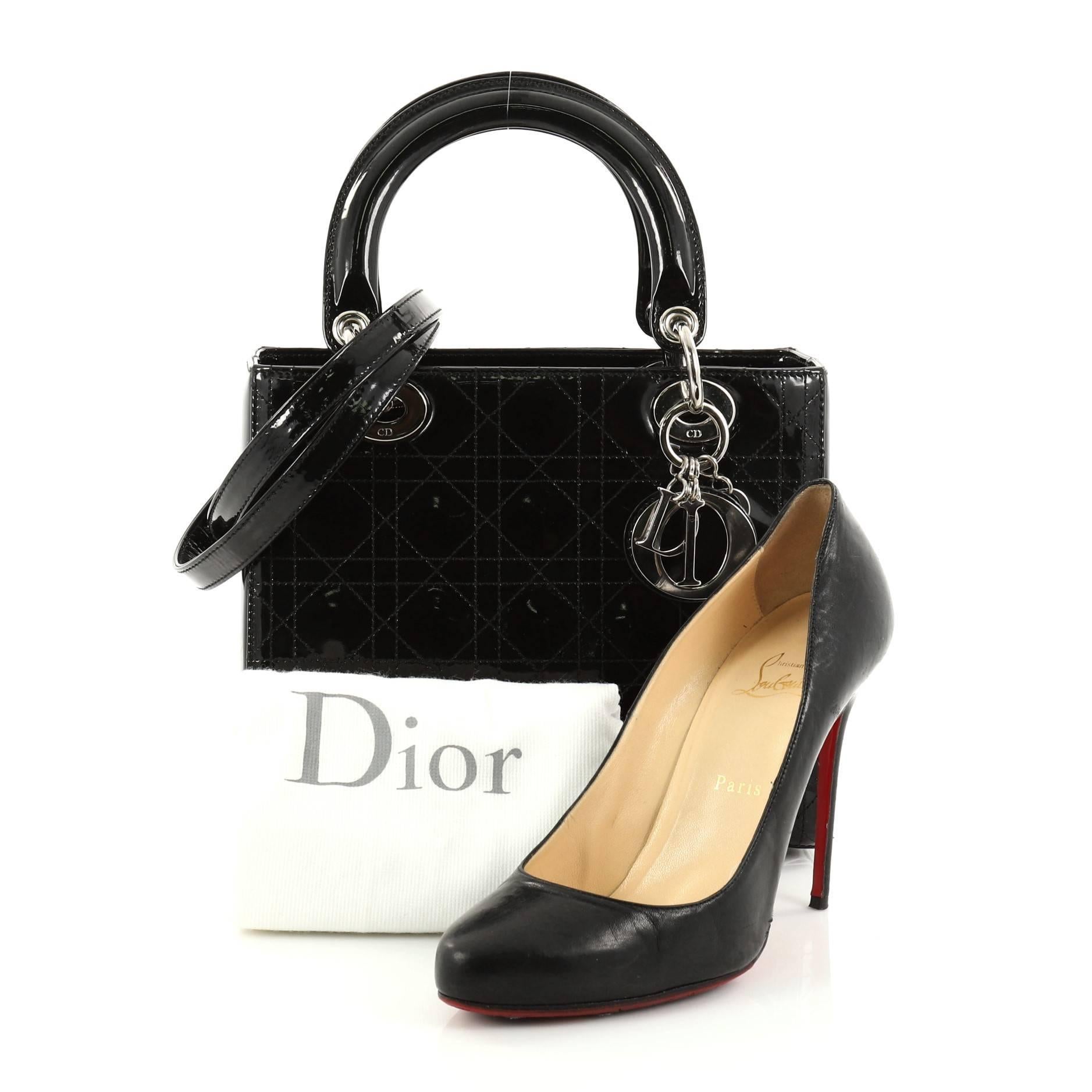 This authentic Christian Dior Lady Dior Handbag Stitched Cannage Patent Medium is an elegant classic bag that every fashionista needs in her wardrobe. Crafted from black patent leather in Dior's iconic cannage stitching, this boxy bag features short