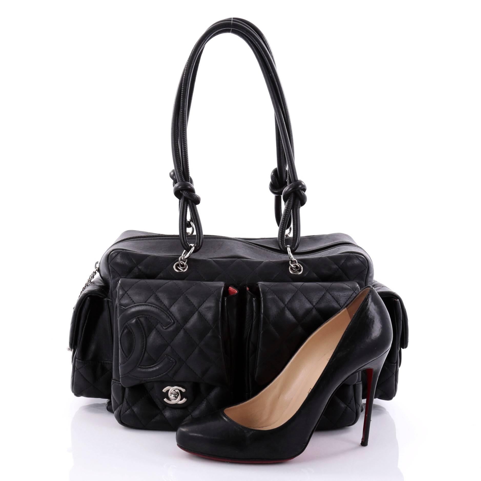 This authentic Chanel Cambon Multipocket Reporter Handbag Quilted Lambskin Large is a practical bag with a chic and stylish appeal. Constructed from black diamond quilted lambskin leather, this bag features tall dual leather-rolled knotted handles,