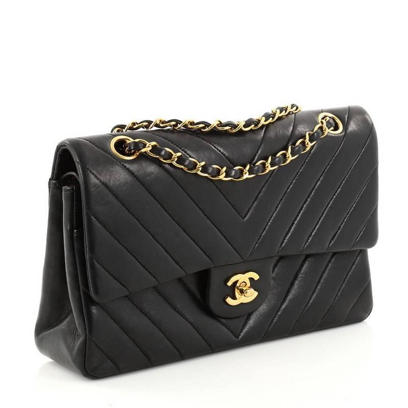 This authentic Chanel Vintage Classic Double Flap Bag Chevron Lambskin Medium exudes a classic yet easy style made for the modern woman. Crafted from black chevron lambskin leather, this elegant flap features woven-in leather gold chain straps,