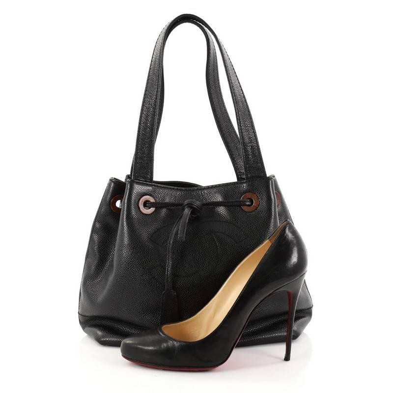 This authentic Chanel Vintage CC Drawstring Shoulder Bag Caviar Medium is a timeless, elegant bucket bag that is ideal for everyday use. Crafted in black caviar leather, this chic shoulder bag features dual flat leather shoulder straps, large CC