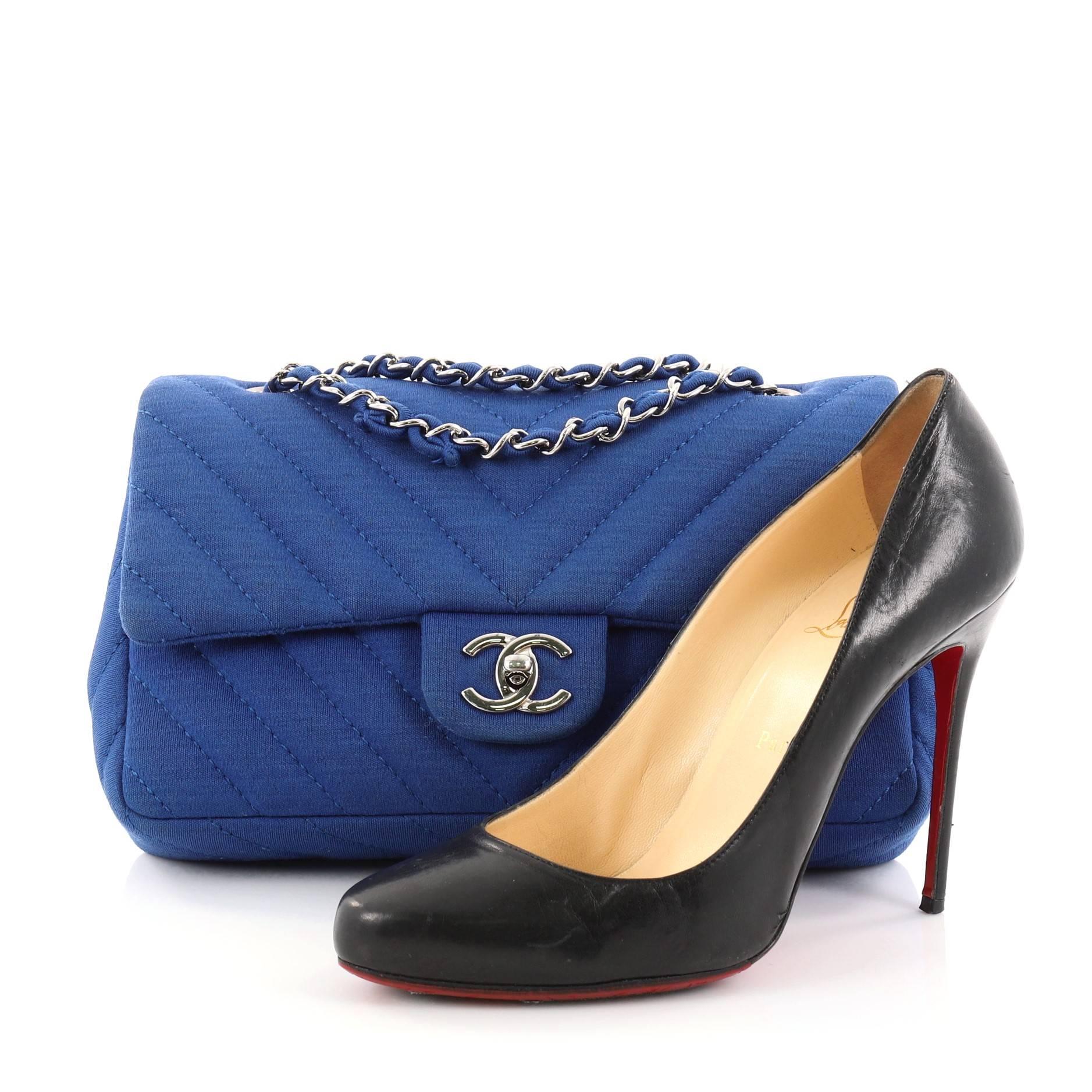 This authentic Chanel Classic Single Flap Bag Chevron Jersey Mini is a timeless essential for any modern woman. Crafted in blue jersey, this classic flap bag features woven-in leather silver chain strap, Chanel's signature chevron quilting, exterior