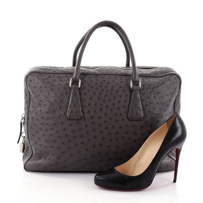 This authentic Prada Zip Around Briefcase Ostrich Large is a chic and functional work-travel accessory made for stylish professionals. Crafted from genuine grey ostrich skin, this briefcase features dual-rolled top handles, raised inverted triangle