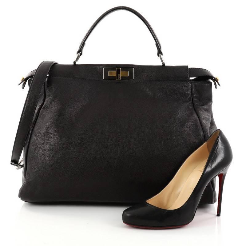 This authentic Fendi Peekaboo Handbag Leather Large is one of Fendi's best-known designs exuding a luxurious yet minimalist appearance. Crafted in black leather, this versatile and stylish satchel features a flat leather top handle, protective base