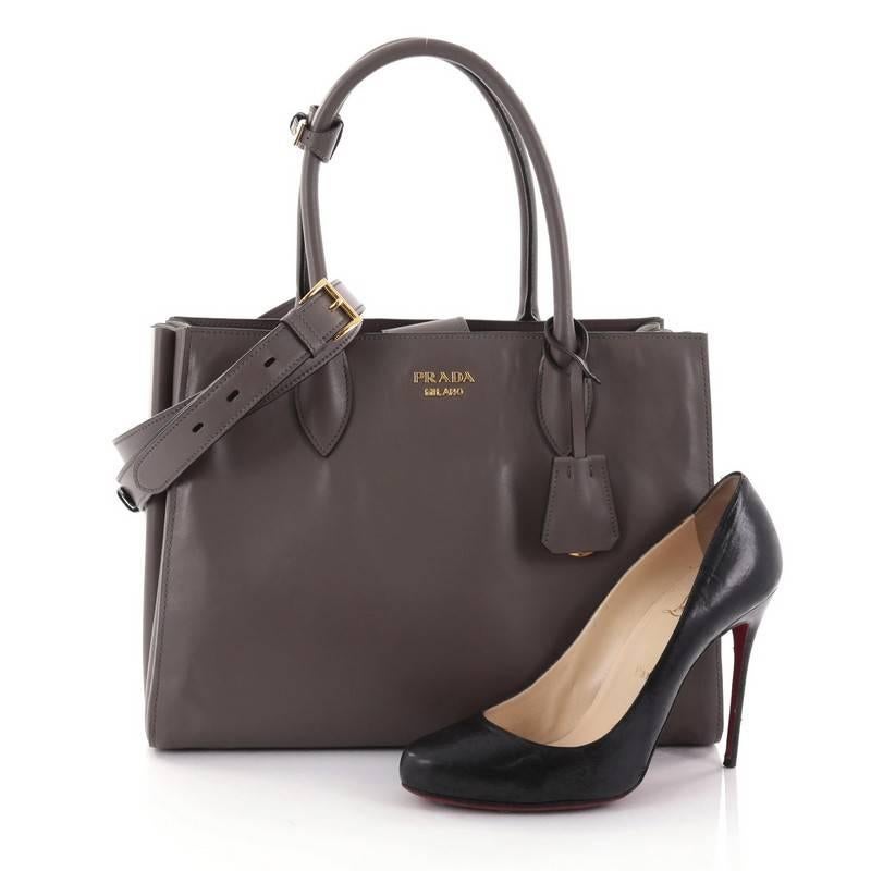 This authentic Prada Soft Bibliotheque Handbag City Calfskin Medium is a mark of Prada's fine craftsmanship that is elegant in its simplicity and structure. Crafted from gray leather, this tote features dual-rolled handles, accordion sides for