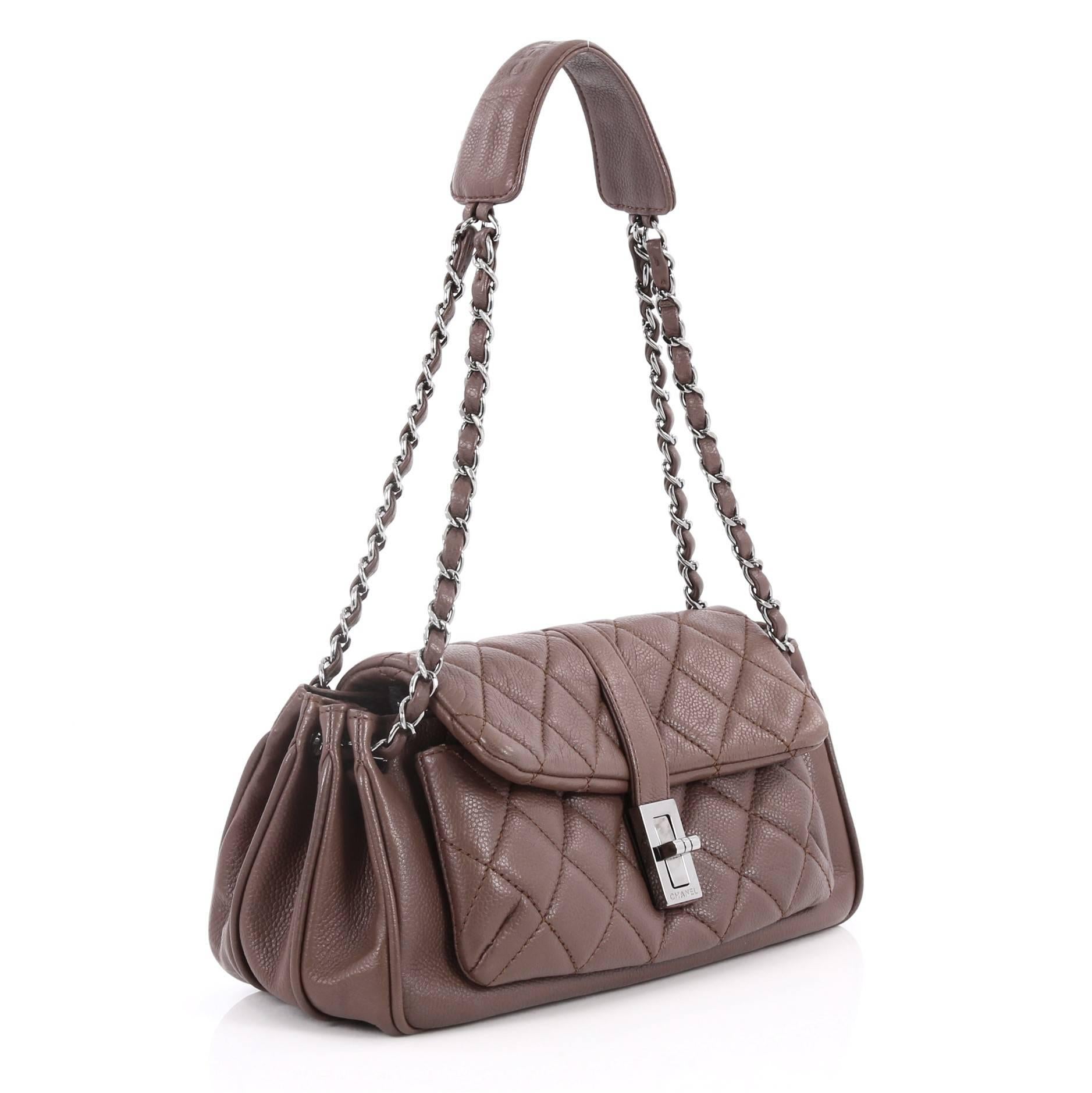 This authentic Chanel Vintage Mademoiselle Lock Accordion Flap Bag Quilted Caviar Medium is perfect for everyday use. Crafted in dark taupe caviar leather, this accordion flap bag features woven-in leather chain link strap, top flap with turn-lock