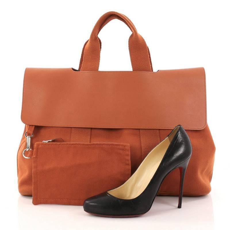 This authentic Hermes Valparaiso Handbag Toile and Leather MM showcases a simple yet chic tote perfect for daily excursions and light traveling. Crafted in orange leather and toile canvas, this travel bag features flap closure and snap buttons, dual
