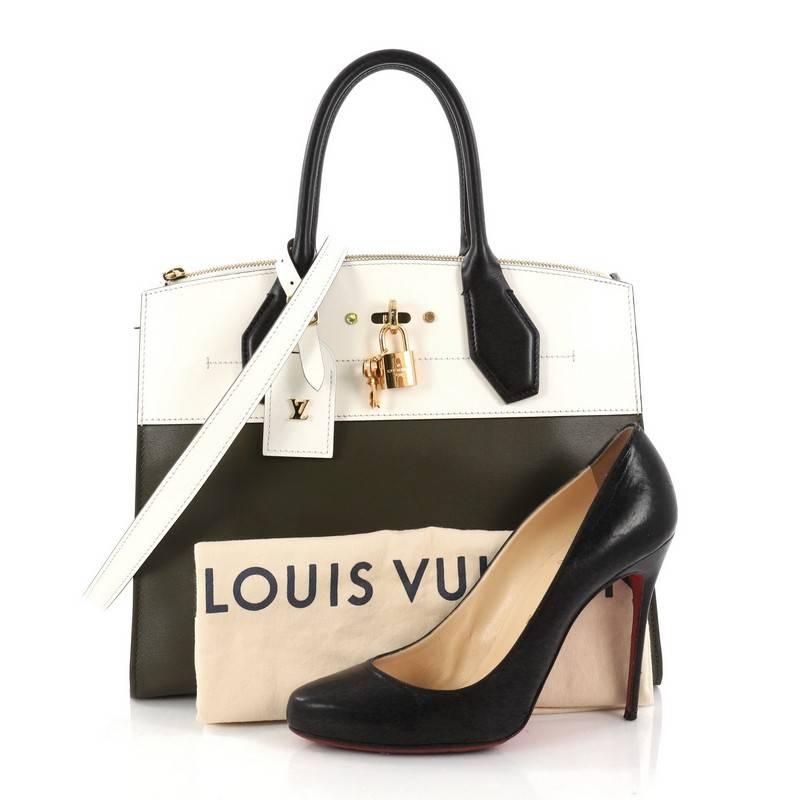 This authentic Louis Vuitton City Steamer Handbag Leather MM designed by Nicholas Ghesquiere is an elegant structured bag made for everyday use. Crafted in olive and ivory calfskin leather, this modern day tote features dual-rolled leather handles,