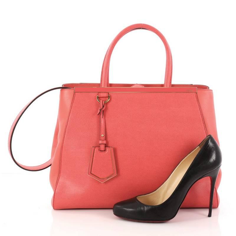 This authentic Fendi 2Jours Handbag Leather Medium is impeccably stylish with a simple silhouette and structured design. Finely crafted in pink leather with soft calfskin sides, this popular tote features a shining top bar that dons the Fendi brand