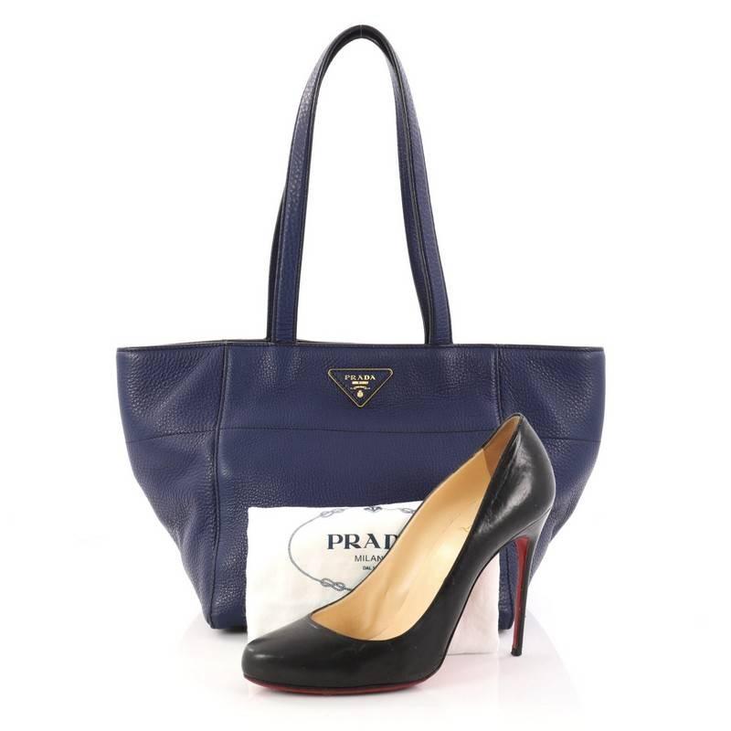 This authentic Prada Open Tote Vitello Daino Small is a chic and stylish everyday bag for casual looks. Crafted from dark blue vitello daino leather, this simple, functional tote features dual-flat leather handles, signature Prada logo, protective