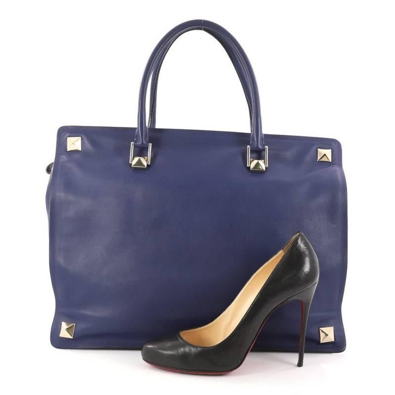 This authentic Valentino Rockstud Four Corner Tote Leather Large is a minnimalist and chic bag perfect for your daily excursions. Crafted in blue leather, this dual-rolled leather handles, stud detailing on handle base, rock stud detailing on the