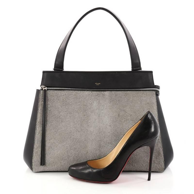 This authentic Celine Edge Bag Pony Hair Medium is the quintessential C̩line design mixing minimalism with luxury. Crafted with luxurious gray pony hair and smooth black leather, this bag features large silver zip-around hardware, exterior back
