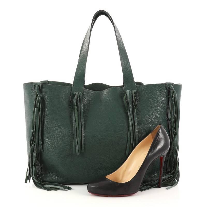 This authentic Valentino C-Rockee Fringe Tote Leather Medium mixes the brand's penchant for bohemian style with modern, chic flair made for any fashionista. Crafted from green pebbled leather, this effortless tote features hand-knotted long leather