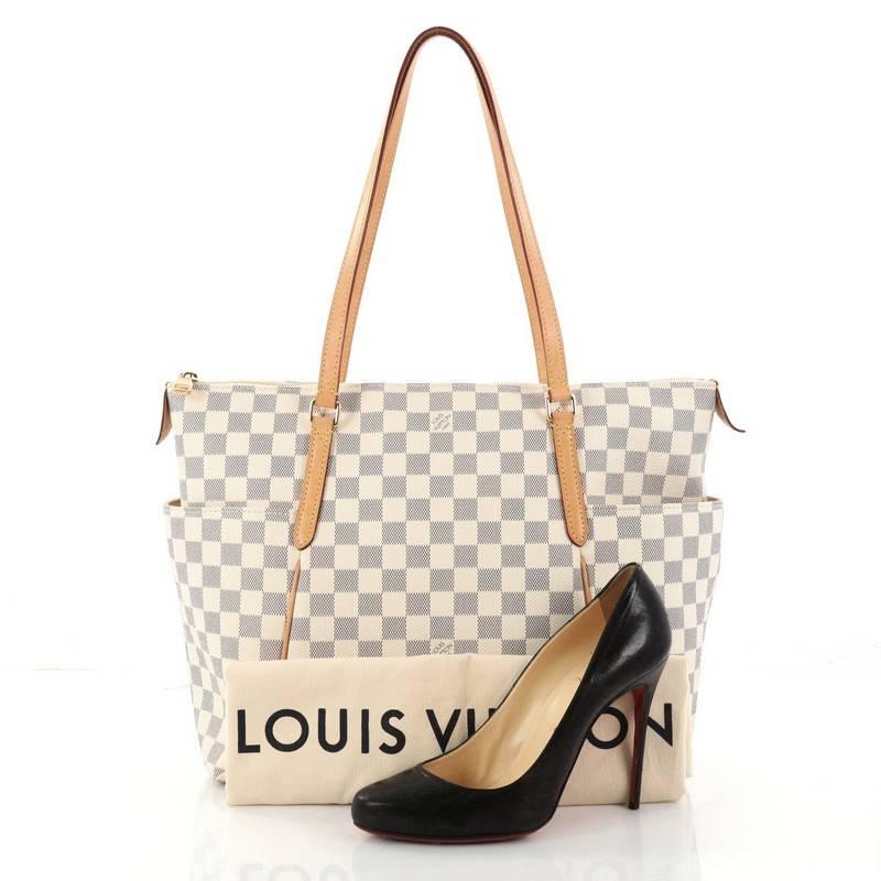 This authentic Louis Vuitton Totally Handbag Damier MM from 2017 is a chic and practical bag for everyday occasions. Crafted from Louis Vuitton's iconic damier azur coated canvas, this simple city tote features tall cowhide leather handles and
