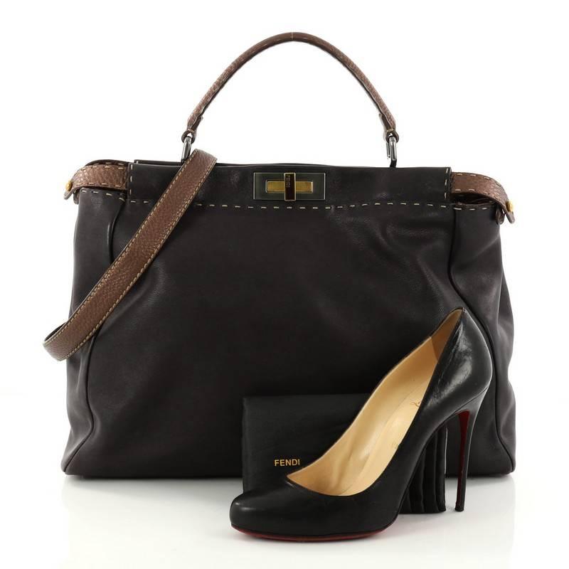 This authentic Fendi Bicolor Selleria Peekaboo Handbag Leather Large is one of Fendi's best-known designs exuding a luxurious yet minimalist appearance. Crafted in navy blue leather, this versatile and stylish satchel features a flat brown leather