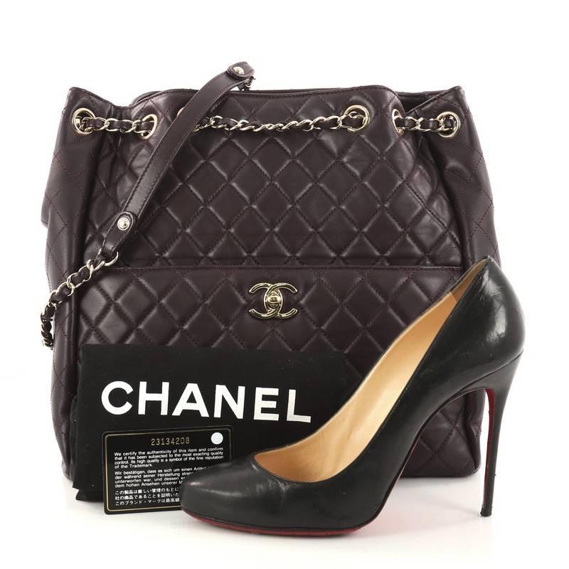 This authentic Chanel Drawstring CC Lock Bucket Bag Quilted Lambskin Medium from 2017 exudes a nature of casual femininity. Crafted from purple lambskin leather, this bucket bag features Chanel's signature diamond quilted leather design, woven-in