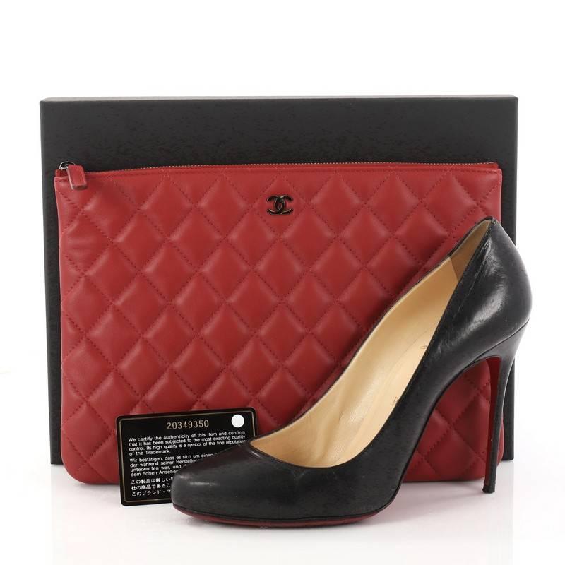 This authentic Chanel O Case Clutch Quilted Lambskin Medium adds a touch of elegance to your everyday outfits. Crafted from red quilted lambskin, this chic clutch features a tiny CC logo on the front and gunmetal-tone hardware accents. Its zip