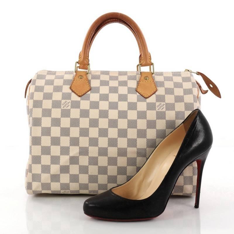 This authentic Louis Vuitton Speedy Handbag Damier 30 is a timeless favorite of many. Constructed from Louis Vuitton's signature damier azur coated canvas, this iconic Speedy features dual-rolled handles, vachetta leather trims and gold-tone