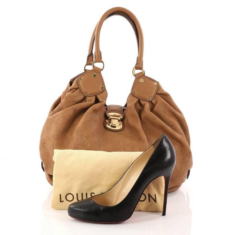 This authentic Louis Vuitton L Hobo Mahina Leather is sleek and refined in design apt for the modern woman. Crafted in camel perforated monogram mahina leather, this feminine hobo features dual-rolled handles, buckle and stud details, side belt