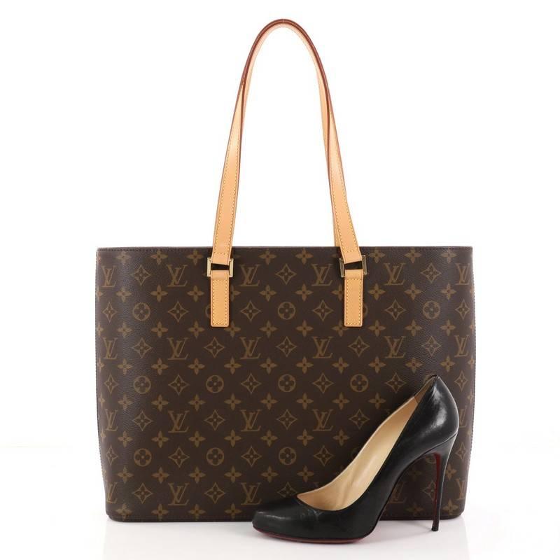 This authentic Louis Vuitton Luco Handbag Monogram Canvas is a classic tote that displays fashion and functionality all rolled into one. Crafted with the brand's iconic brown monogram coated canvas, this tote features dual flat leather handles, a
