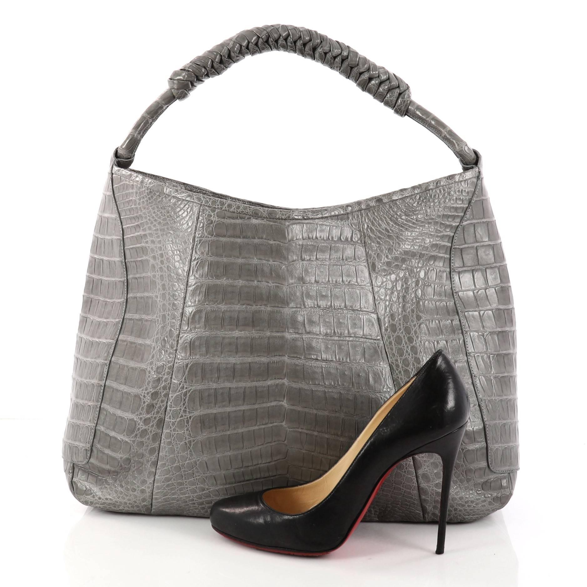 This authentic Nancy Gonzalez Braided Handle Hobo Crocodile Medium is a luxurious bag perfect for the modern fashionista. Crafted from genuine grey crocodile skin, this bag features a braided shoulder strap and gold-tone hardware accents. It opens