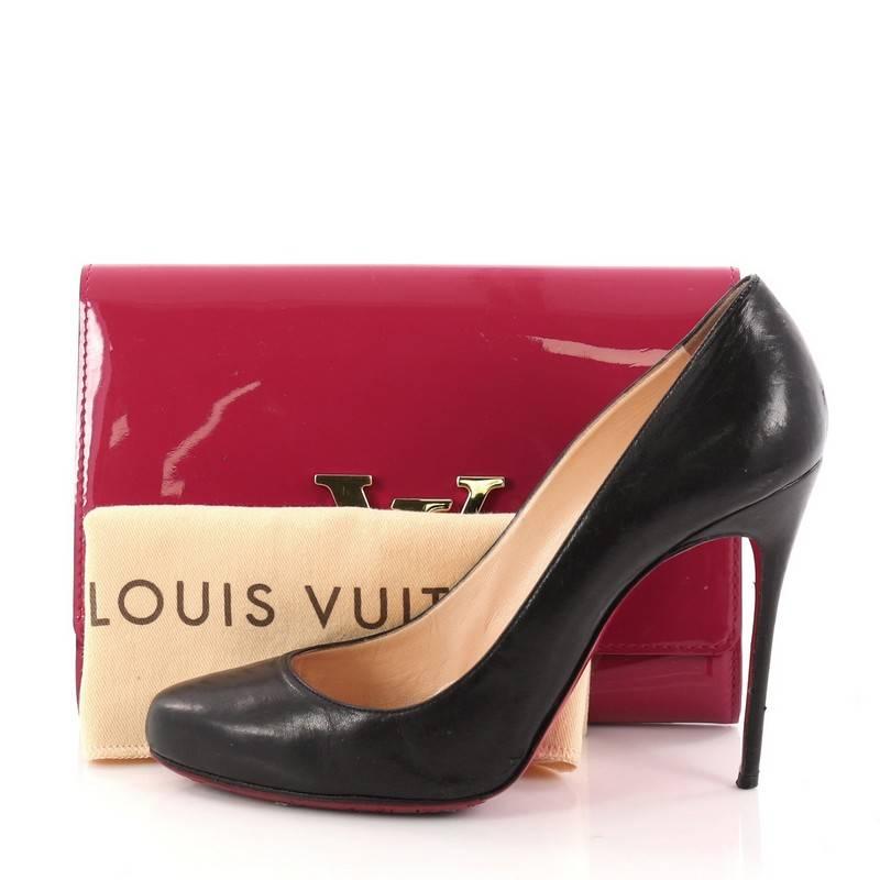 This authentic Louis Vuitton Louise Clutch Patent MM is perfect for nights out. Crafted in striking dark pink patent leather, this modern yet feminine clutch features an oversized LV logo flip lock clasp closure in sleek design and gold-tone