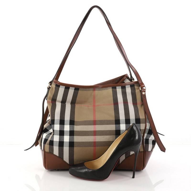 Cet authentique Burberry Canterbury Tote House Check Canvas Medium est parfait pour une tenue décontractée. Confectionné dans la toile à carreaux de la marque:: ce fourre-tout est doté de deux grandes poignées réglables:: de garnitures en cuir