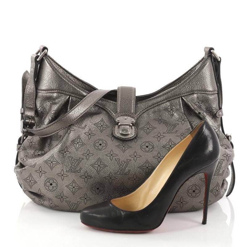 This authentic Louis Vuitton XS Crossbody Bag Mahina Leather is both stylish and functional. Crafted from pewter grey perforated mahina leather, this shoulder bag features an adjustable leather strap, protective base studs, top flap with slide-lock