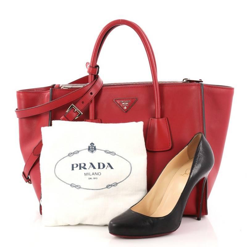 This authentic Prada Twin Pocket Tote City Calfskin Large showcases a modern silhouette perfect for today's woman. Crafted from red leather, this stylish and functional tote features dual-rolled handles, expanded winged sides, raised Prada logo at