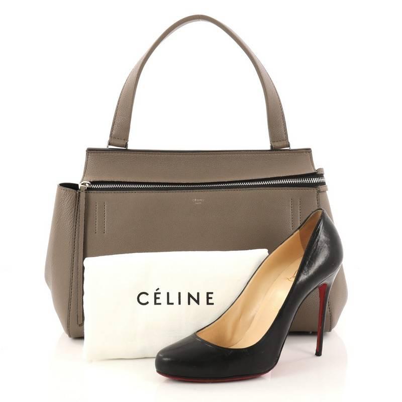 this authentic Celine Edge Bag Leather Medium is the quintessential Celine design mixing minimalism with luxury. Crafted in taupe leather, this bag features an exterior back pocket, single looped shoulder strap, gold stamped Celine logo, protective