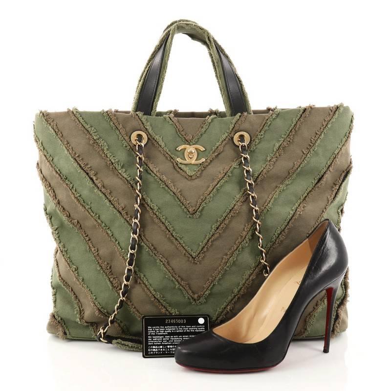 This authentic Chanel Shopping Tote Chevron Canvas Patchwork Large is from the brand's Cruise 2017 Cuba Collection. Crafted from green and khaki chevron patchwork canvas, this jaw-dropping bag features dual top handles, woven-in leather chain straps