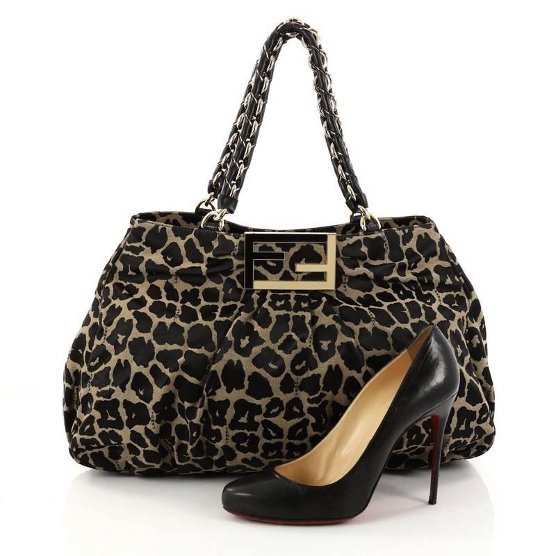 This authentic Fendi Mia Tote Printed Fabric Large is feminine yet edgy in design. Crafted from black and beige printed fabric, this tote features woven-in leather chain handles, intricate pleating, giant Fendi logo and gold-tone hardware accents.