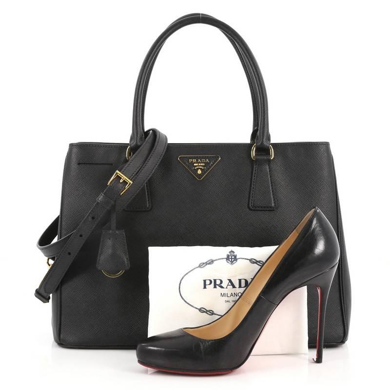 This authentic Prada Lux Open Tote Saffiano Leather Medium is elegant in its simplicity and structure. Crafted from black saffiano leather, this sturdy and spacious tote features dual-rolled handles, gusseted side with snap buttons, iconic Prada