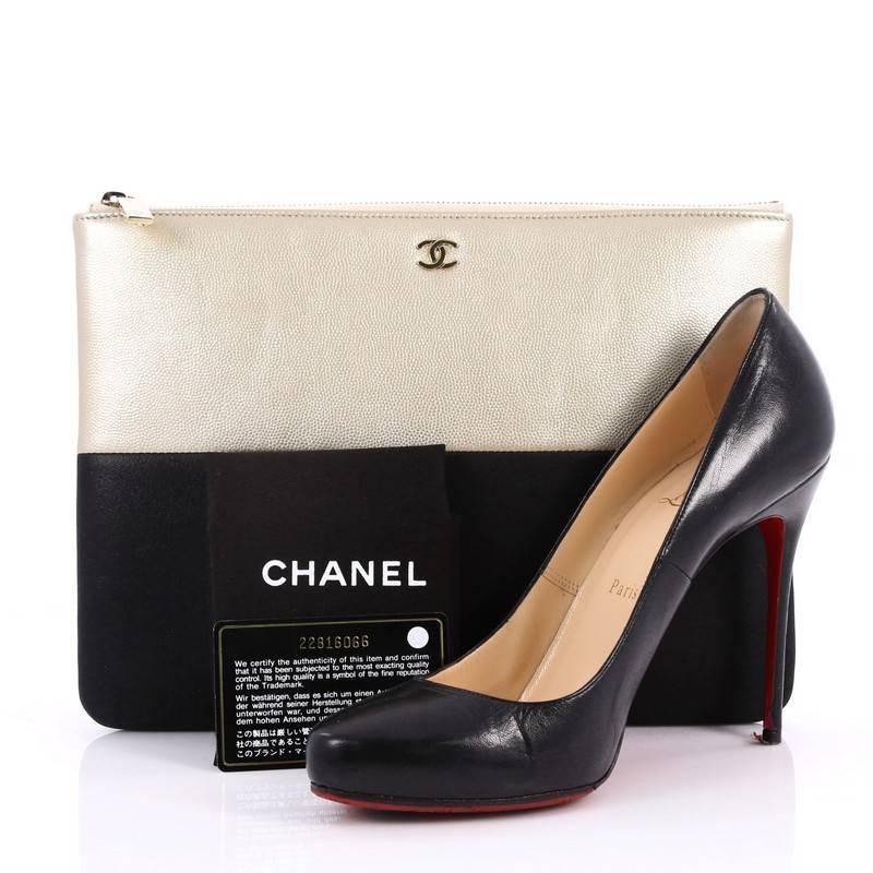This authentic Chanel Bicolor O Case Clutch Caviar and Iridescent Calfskin Medium adds a touch of elegance to your everyday outfits. Crafted from champagne caviar leather and black iridescent calfskin, this chic clutch features a tiny CC logo on the