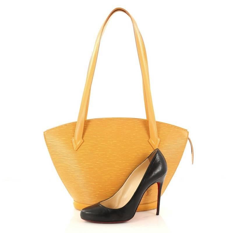 This authentic Louis Vuitton Saint Jacques Handbag Epi Leather PM is refined and elegant. Crafted from Louis Vuitton's signature yellow epi leather and sturdy base, this fan-shaped bag features long straps, subtle LV logo at the front and gold-tone